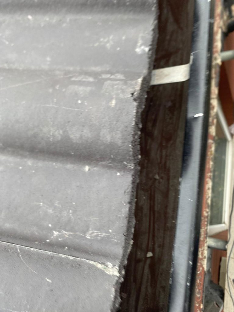 Detailed view of brand new charcoal concrete roof tiles with a crisp ridge line and a new Velux flush in the slope.